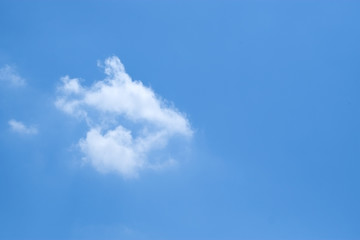 Group of small white fluffy clouds and blue sky.