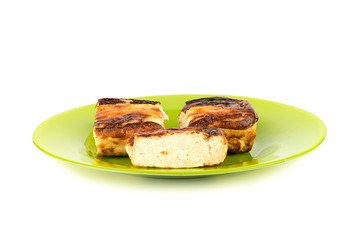 Three pieces of cottage cheese casserole on a green plate over a white background.