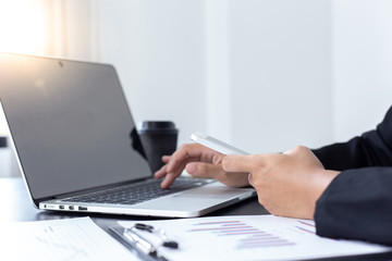 Financial businessmen use laptop and smart phone to analyze marketing strategies and real estate data to reduce company taxes for their customers, Accounting and Tax concept.