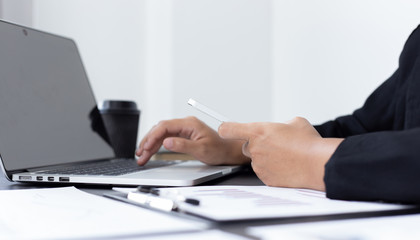 Fototapeta premium Financial businessmen use laptop and smart phone to analyze marketing strategies and real estate data to reduce company taxes for their customers, Accounting and Tax concept.