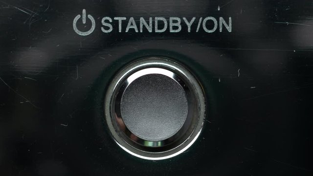 Man Finger Pressing Button Standby On Off Silver DVD Player.