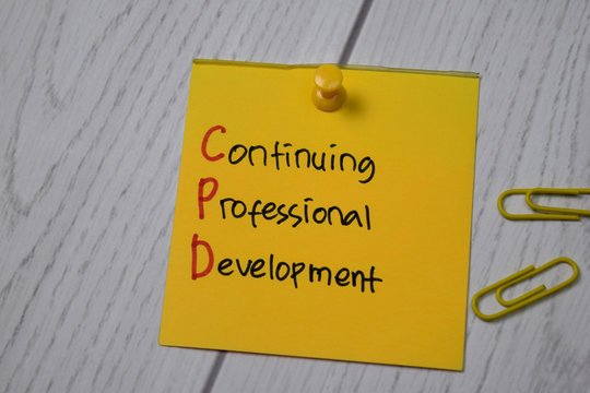 Continuing Professional Development write on sticky note isolated on wooden table.