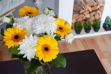 bouquet of chrysanthemums on a dark table near a white fireplace