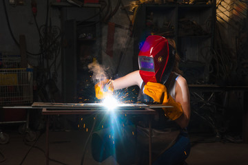 Portrait industrial worker craft labourer factory welding steel structure with spark.