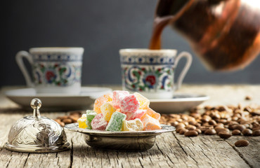 Turkish delight in hollowware and pouring turkish coffee in porcelain cup, traditional fruity flavored turkish sweet food
