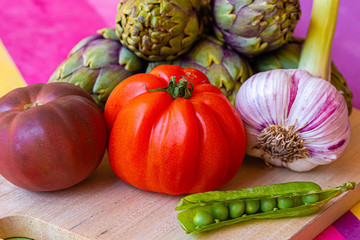 still life with garlic, tomato, green peas and pepper artichokes
