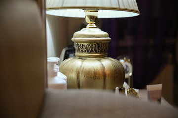 Bronze vintage lamp on the bedside table next to the bed