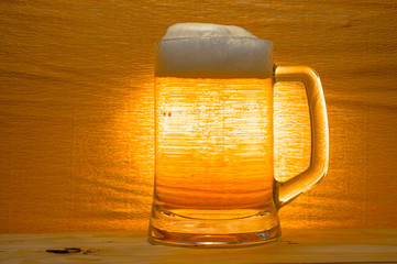 Classic beer mug filled with beer. Tasty, soft beer on a bright background.