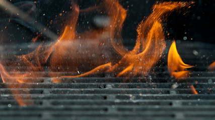 Cast iron grate with Fire flames and sparkles, macro shot