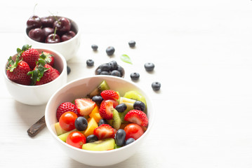 Healthy foods  Concept ,blueberry  strawberry apple  with salad  in  bowl on white wood background