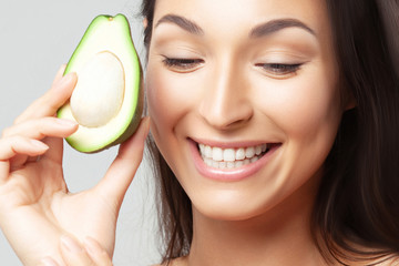 Young beautiful woman with avocado closeup