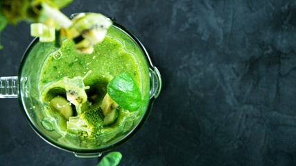 Green fresh smoothie blended in blender, top view. Healthy eating concept.