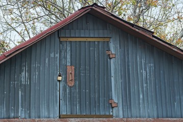 one gray rural wooden attic with a closed door