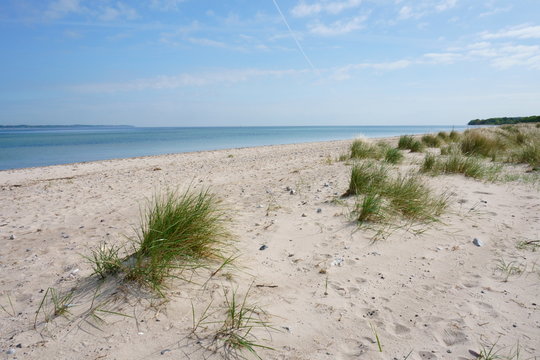 Wei&szlig;er Ostsee Sand Strand mit D&uuml;nen und blauem Himmel