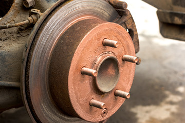 An old rusty hub without a wheel. Brake disc and brake caliper on the car