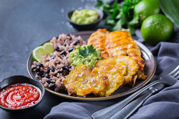 Rice with black beans, fried chicken breast and tostones, plantains