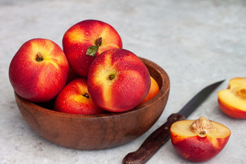 Fresh ripe nectarines in a wooden bowl
