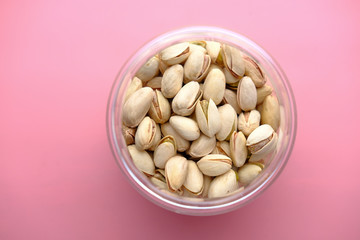 Top view of a bowl of pistachios nut on pink 