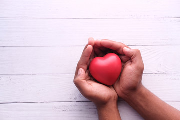 Red heart in hands, donate or charity concept