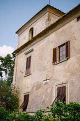 Fototapeta na wymiar Facade of an old villa in Italy, in Florence. Stone stairs, wooden windows with shutters.