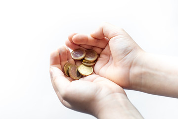 Closeup child's hands holding Euro coins isolated on white background, human hands and saving concepts, or pocket money concept.