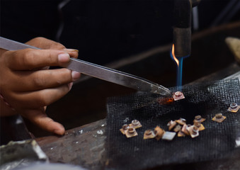 A person is melting silver to make jewellery. Craftsman at work