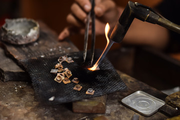 A person is melting silver to make jewellery. Craftsman at work