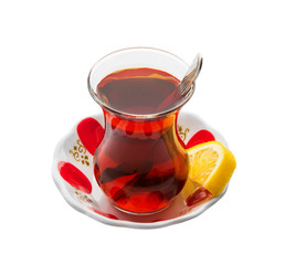 Turkish Tea in traditional glass with traditional tea plate. Turkish Tea glass with thin waist with lemon slice. Isolated white background. Clipping Path..