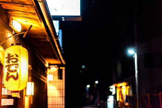 Osaka, Japan Minami Namba famous street dark night and illuminated yellow paper lanterns and generic sign for famous oden soup hot pot dish
