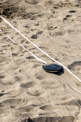 Measuring tape in the sand. Social distancing due to COVID safety measures on a famous italian beach in the Riviera Romagnola area, between Rimini, Riccione and Cervia. Season opening after lockdown.