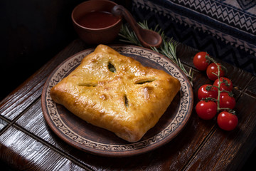 Hospitable Georgian cuisine. Khachapuri with meat on a wooden background
