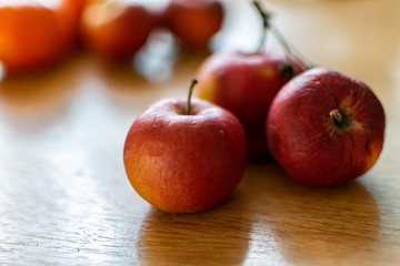 Bright juicy fruits, natural and natural fruits with damage. Red apples and tangerines on a modern brown light table