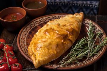 Hospitable Georgian cuisine. Khachapuri with cheese on a wooden background