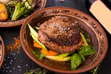 grilled steak with greens in a round ethnic plate. Georgian cuisine
