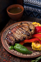grilled steak with greens in a round ethnic plate. Georgian cuisine