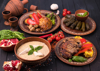 Fototapeta na wymiar Hospitable Georgian cuisine. Set with delicious food on ethnic plates
