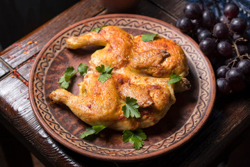 Grilled chicken with greens in a round ethnic plate. Georgian cuisine