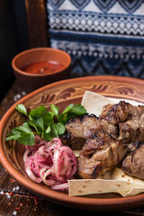 Grilled meat on pita with pickled onions and herbs
