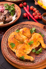 Grilled chicken with greens in a round ethnic plate. Georgian cuisine