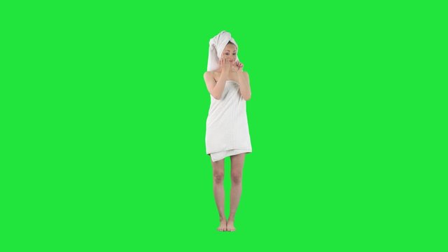 Naughty young woman in bath towel showing middle finger mocking and laughing. Full body length keyed out on green screen background. 