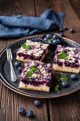 Delicious juicy dessert, blueberry pie slices topped with a sweet crunchy streusel, decorated with...