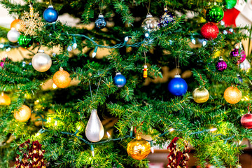 Obraz na płótnie Canvas Christmas xmas tree background with red, blue orange and green ornaments festive decorations holiday pattern shiny