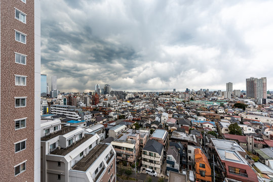 Shinjuku, Tokyo dark gloomy grey cityscape with high angle above view apartment buildings residential area on cloudy stormy overcast day with many houses