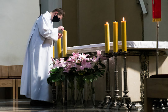 Priest With Protective Face Mask In A Church During Covid Or Coronavirus Emergency, Reopening Church To Celebrate Mass