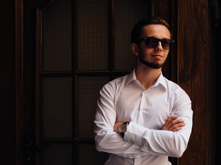 portrait young guy with a beard in sunglasses and white shirt. s