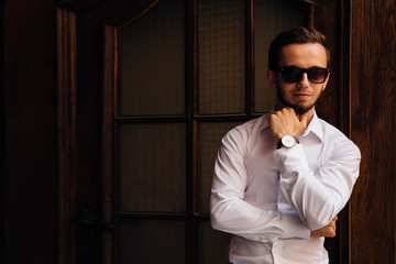 Studio portrait of young guy with white shirt and sunglasses nea