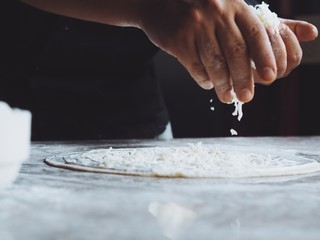 Close up pastry chef hands with dough and flour for making a pizza, bread, pasta.