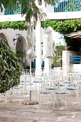 No visitors on restaurant's outdoor seating area. Beautiful seating place cafe exterior. Catering business crisis because of coronavirus pandemic, quarantine and self isolation. Siesta. Vertical image