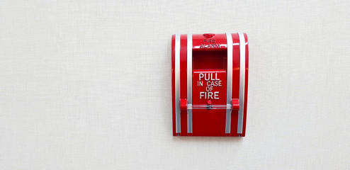 Fire alarm switch box for pull in case of fire isolated on grey or gray wall background with right copy space. Prevent emergency event concept