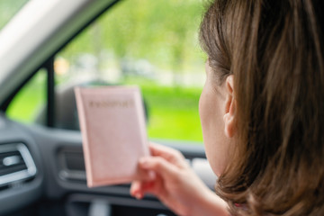 Passenger girl holding passport sitting in car for check customs officers. Border control concept....